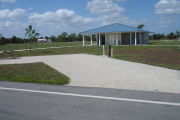 Photo: 023, Campsite with picnic table, grill and fire ring on the left and water and electric on the left. A restroom is nearby.