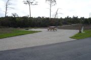 Photo: 024, Campsite with picnic table, grill and fire ring on the left and water and electric on the left. A restroom is nearby.