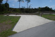 Photo: 025, Campsite with picnic table, grill and fire ring on the left and water and electric on the left. A restroom is nearby.