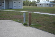 Photo: 026, Site number next to water and electric hooks ups at the back of a gravel site.