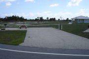 Photo: 029, Campsite with picnic table, grill and fire ring on the left and water and electric on the left. A restroom is nearby.