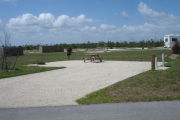 Photo: 033, Campsite with picnic table, grill and fire ring on the left and water and electric on the left.