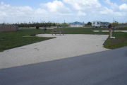 Photo: 035, Campsite with picnic table, grill and fire ring on the left and water and electric on the left. A restroom is nearby.