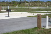 Photo: 036, Site number next to water and electric hooks ups at the back of a paved site.