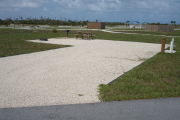Photo: 039, Campsite with picnic table, grill and fire ring on the left and water and electric on the left.