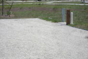 Photo: 040, Site number next to water and electric hooks ups at the back of a gravel site.