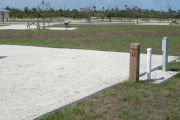 Photo: 041, Site number next to water and electric hooks ups at the back of a gravel site.