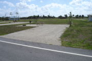 Photo: 042, Campsite with picnic table, grill and fire ring on the left and water and electric on the left. A restroom is nearby.
