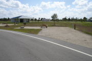 Photo: 046, Campsite with picnic table, grill and fire ring on the left and water and electric on the left. A restroom is nearby.