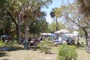 A view of the Histroic Koreshan Settlement on Earth Day 2010, with visitors stopping by the many exhibitors tents present on the ground or sitting in the shade to listen  one of the bands on the covered stage.