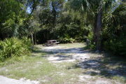 Picnic table and cloths posts toward rear of partly grassy site.