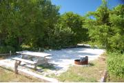 Photo: 021, With the picnic table and fire ring in the front, the shadows from the buttonwood trees around the site cover the sand.