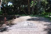 This is a picture of campsite 1 looking from the road into the partly sunny site.  This site has 50amp service and water hookups.  There is a gravel foundation with a picnic table and a ground campfire ring.