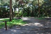 This is a picture of campsite 2 looking from the road into the partly sunny site.  This site has 50amp service and water hookups.  There is a gravel foundation with a picnic table and a ground campfire ring.