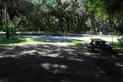 This is a picture of campsite 4 from the back of the site looking toward the road.   The site has water and 50amp electric service.  This is a partly sunny site with a gravel foundation.  The site has a picnic table and a ground campfire ring.