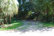 Campsite 5 is a partial sunny site with a gravel foundation located on the right hand side of the road.  Looking into the site on the right is the water and 50amp electrical service. There is a picnic table and ground campfire ring.  At the front left side of the site is the brown site marker.