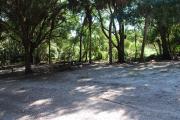 This is a picture of campsite 7 looking from the road into the partly sunny site.  This site has 50amp service and water hookups.  There is a gravel foundation with a picnic table and a ground campfire ring.