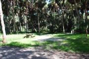 Campsite 12 is a partial sunny site with a gravel foundation located on the right hand side of the road.  Looking into the site on the right is the water and 50amp electrical service. There is a picnic table and ground campfire ring.  At the front left side of the site is the brown site marker.