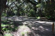 This is a picture of campsite 14 from the back of the site looking toward the road.   The site has water and 50amp electric service.  This is a shady site with a gravel foundation.  The site has a picnic table and a ground campfire ring.