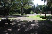 This is a picture of campsite 18 from the back of the site looking toward the road.   The site has water and 50amp electric service.  This is a partly sunny site with a gravel foundation.  The site has a picnic table and a ground campfire ring.