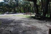 This is a picture of campsite 22 from the back of the site looking toward the road.   The site has water and 50amp electric service.  This is a partly sunny site with a gravel foundation.  The site has a picnic table and a ground campfire ring.