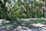 Campsite 26 is a shady tent only site with a gravel foundation located on the right hand side of the road.  Looking into the site on the right is the water and 50amp electrical service. There is a picnic table and ground campfire ring.  At the front left side of the site is the brown site marker.