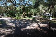 This is a picture of campsite 28 from the back of the site looking toward the road.   The site has water and 50amp electric service.  This is a partly sunny site with a gravel foundation.  The site has a picnic table and a ground campfire ring.