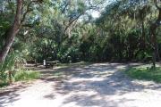 This is a picture of campsite 28 looking from the road into the partly sunny site.  This site has 50amp service and water hookups.  There is a gravel foundation with a picnic table and a ground campfire ring.