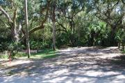 Campsite 29 is a partial sunny site with a gravel foundation located on the right hand side of the road.  Looking into the site on the right is the water and 50amp electrical service. There is a picnic table and ground campfire ring.  At the front left side of the site is the brown site marker.