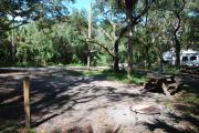 This is a picture of campsite 29 from the back of the site looking toward the road.   The site has water and 50amp electric service.  This is a partly sunny site with a gravel foundation.  The site has a picnic table and a ground campfire ring.
