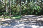 This is a picture of campsite 29 looking from the road into the partly sunny site.  This site has 50amp service and water hookups.  There is a gravel foundation with a picnic table and a ground campfire ring.
