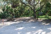 Campsite 32 is a partial sunny site with a gravel foundation located on the right hand side of the road.  Looking into the site on the right is the water and 50amp electrical service. There is a picnic table and ground campfire ring.  At the front left side of the site is the brown site marker.