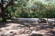 This is a picture of campsite 32 from the back of the site looking toward the road.   The site has water and 50amp electric service.  This is a partly sunny site with a gravel foundation.  The site has a picnic table and a ground campfire ring.