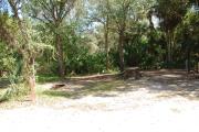 Campsite 33 is a partial sunny site with a gravel foundation located on the right hand side of the road.  Looking into the site on the right is the water and 50amp electrical service. There is a picnic table and ground campfire ring.  At the front left side of the site is the brown site marker.