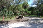 Campsite 34 is a sunny site with a gravel foundation located on the right hand side of the road.  Looking into the site on the right is the water and 50amp electrical service. There is a picnic table and ground campfire ring.  At the front left side of the site is the brown site marker.