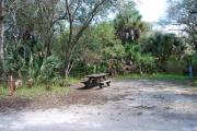 This is a picture of campsite 34 looking from the road into the sunny site.  This site has 50amp service and water hookups.  There is a gravel foundation with a picnic table and a ground campfire ring.