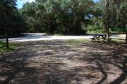 This is a picture of campsite 35 from the back of the site looking toward the road.   The site has water and 50amp electric service.  This is a partly sunny site with a gravel foundation.  The site has a picnic table and a ground campfire ring.