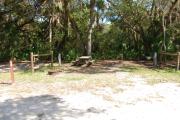 Campsite 36 is a partial sunny site with a gravel foundation located on the right hand side of the road.  Looking into the site on the right is the water and 50amp electrical service. There is a picnic table and ground campfire ring.  At the front left side of the site is the brown site marker.