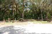 This is a picture of campsite 36 looking from the road into the partly sunny site.  This site has 50amp service and water hookups.  There is a gravel foundation with a picnic table and a ground campfire ring.