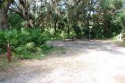 Campsite 38 is a partial sunny site with a gravel foundation located on the right hand side of the road.  Looking into the site on the right is the water and 50amp electrical service. There is a picnic table and ground campfire ring.  At the front left side of the site is the brown site marker.