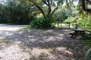 This is a picture of campsite 38 from the back of the site looking toward the road.   The site has water and 50amp electric service.  This is a partly sunny site with a gravel foundation.  The site has a picnic table and a ground campfire ring.