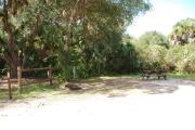 Campsite 40 is a sunny site with a gravel foundation located on the right hand side of the road.  Looking into the site on the right is the water and 50amp electrical service. There is a picnic table and ground campfire ring.  At the front left side of the site is the brown site marker.