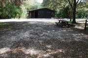 This is a picture of campsite 43 from the back of the site looking toward the road.   The site has water and 50amp electric service.  This is a partly sunny site with a gravel foundation.  The site has a picnic table and a ground campfire ring.