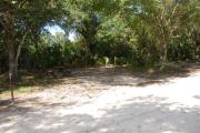 This is a picture of campsite 43 looking from the road into the partly sunny site.  This site has 50amp service and water hookups.  There is a gravel foundation with a picnic table and a ground campfire ring.