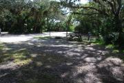 This is a picture of campsite 46 from the back of the site looking toward the road.   The site has water and 50amp electric service.  This is a partly sunny site with a gravel foundation.  The site has a picnic table and a ground campfire ring.