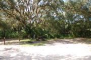 This is a picture of campsite 46 looking from the road into the partly sunny site.  This site has 50amp service and water hookups.  There is a gravel foundation with a picnic table and a ground campfire ring.