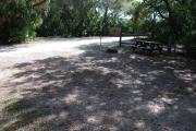 This is a picture of campsite 47 from the back of the site looking toward the road.   The site has water and 50amp electric service.  This is a partly sunny site with a gravel foundation.  The site has a picnic table and a ground campfire ring.