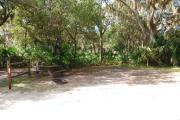 This is a picture of campsite 47 looking from the road into the partly sunny site.  This site has 50amp service and water hookups.  There is a gravel foundation with a picnic table and a ground campfire ring.