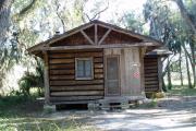 This is a front view picture of Cabin 5 which is a rustic palm log cabin built by the Civilian Conservation Corp. in the mid 1930âs.  There is a living/dining/bedroom area with 2 double beds, a sofa bed, dining set, linen cabinet and fireplace.  There also is a bathroom and a kitchen with coffee maker, toaster, microwave, range, refrigerator, dishes, silverware and cooking utensils.  The cabins sleep up to six.  Off of the back porch there is a fire ring, cooking grill and a picnic table.  There are no pets and no smoking allowed in the cabins.