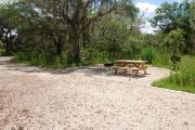 This is picture of campsite #89 from the back of the site looking toward the road.  Site has 50amp electric, water and sewage hook-ups.  This is a partial shady site with stone foundation and vegetation on sides.  There is a separate section to the side with the picnic table, cooking grill and ground campfire ring.